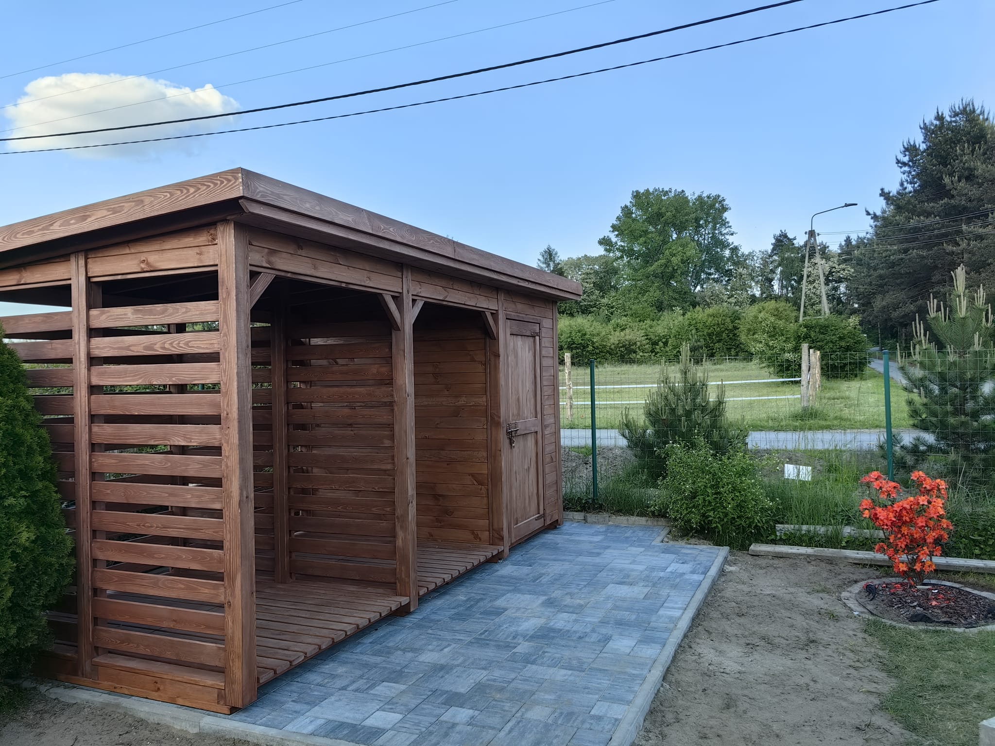 Solidna drewutnia drewniana z małym domkiem – rozwiązanie do składowania drewna przy domu.